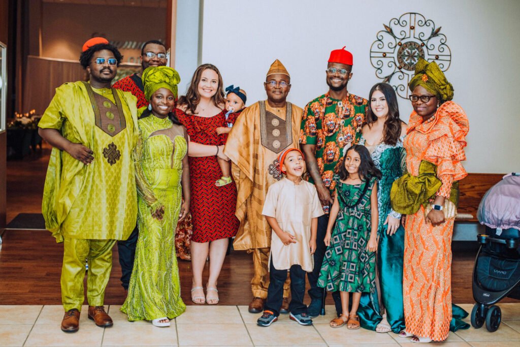 Dr. Festus Ukwuani, president of ACF Washington D.C. chapter and author of “Revival and Restoration in Alignment with God’s Purpose,” stands with his wife, four children, two daughters-in-law, and three grandchildren dressed in vibrant Nigerian attire at a family gathering.